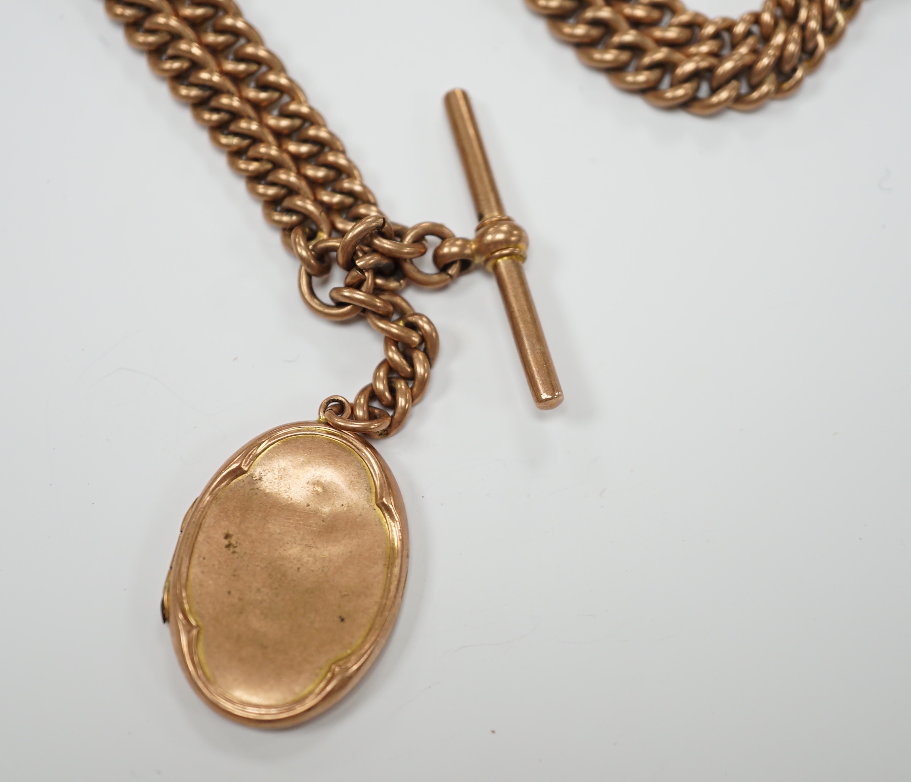 An Edwardian 9ct gold graduated curb link albert, 35cm, hung with a 9ct gold locket, gross 48.6 grams.
